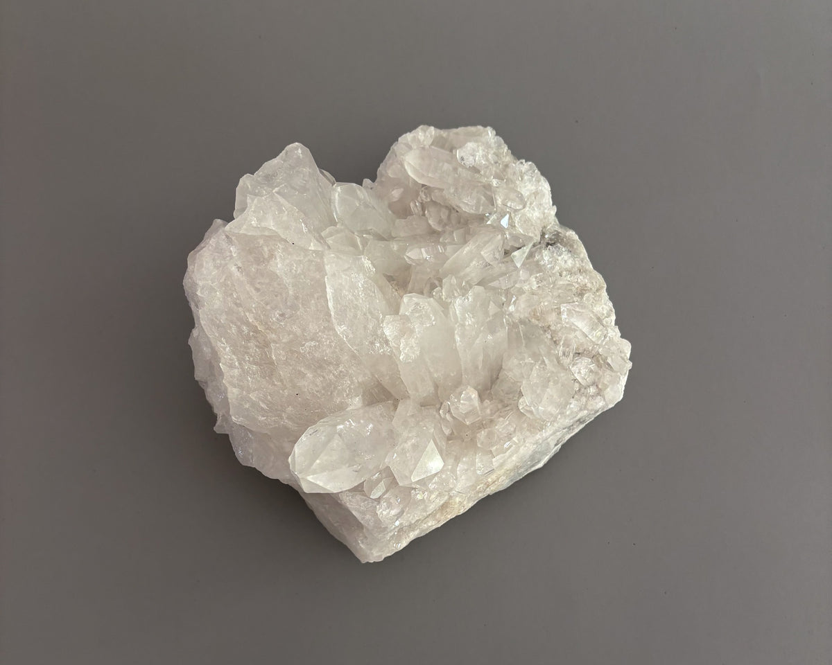 Natural clear quartz crystal cluster with translucent points and unique crystalline formations.