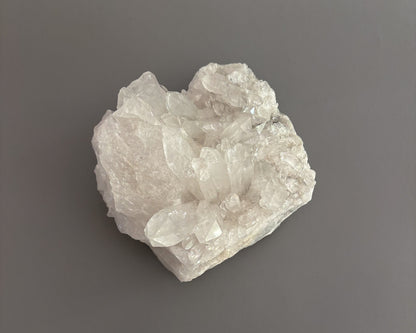 Natural clear quartz crystal cluster with translucent points and unique crystalline formations.