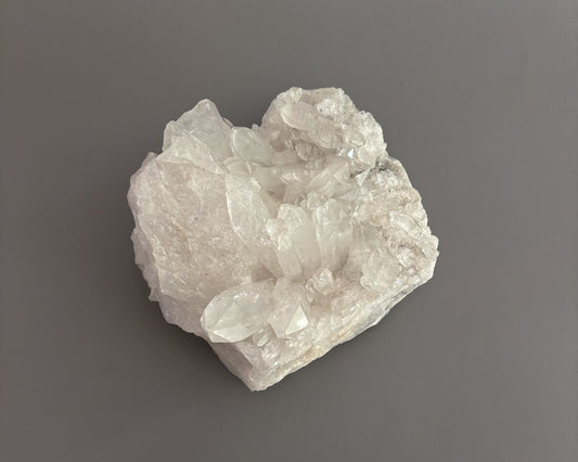 Natural clear quartz crystal cluster with translucent points and unique crystalline formations.