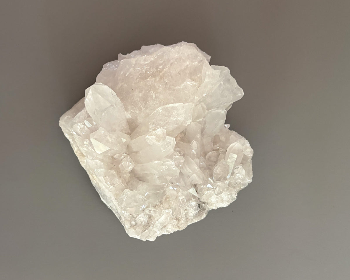 Clear quartz crystal cluster featuring naturally formed transparent and milky white crystal points.