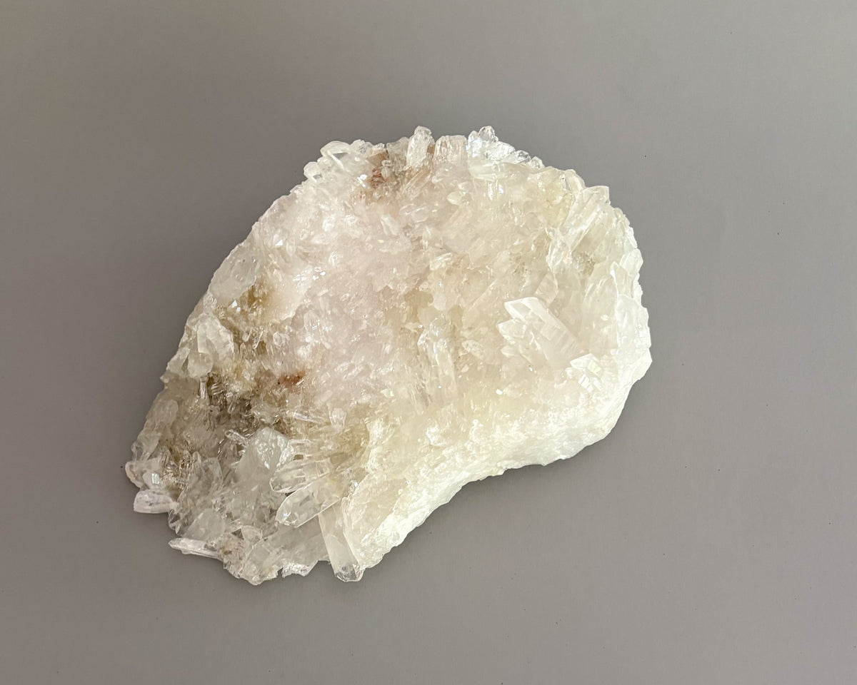 Natural clear quartz crystal cluster with translucent points and unique crystalline formations.