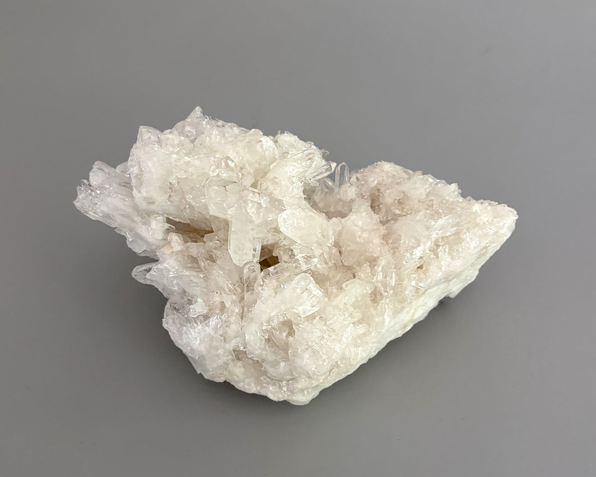 Natural clear quartz crystal cluster with translucent points and unique crystalline formations.