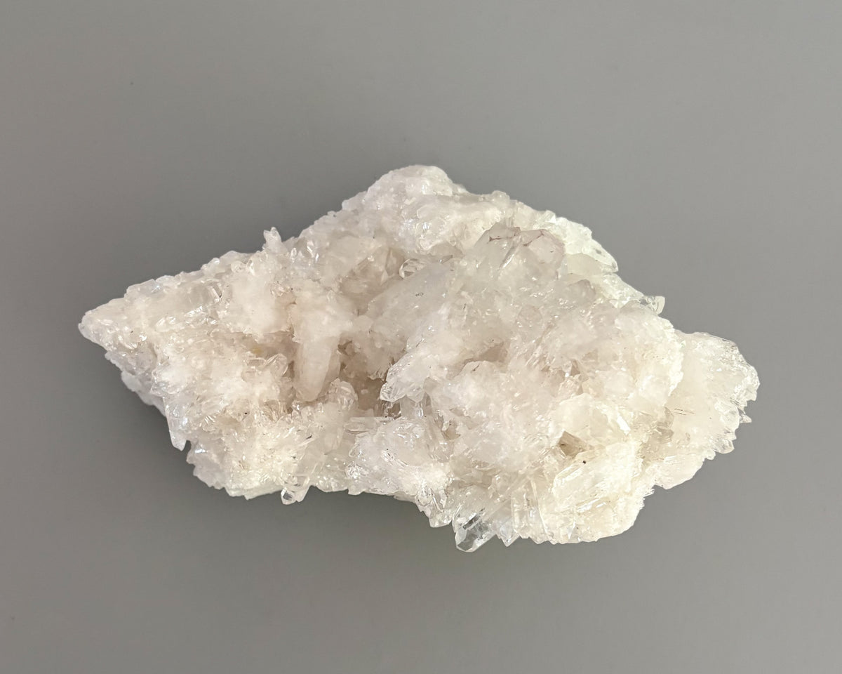 Natural clear quartz mineral specimen with sparkling crystal points and organic formations.