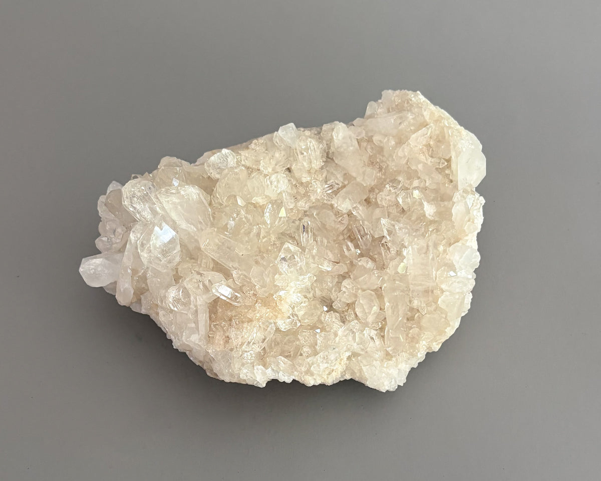 Natural clear quartz crystal cluster with translucent points and unique crystalline formations.