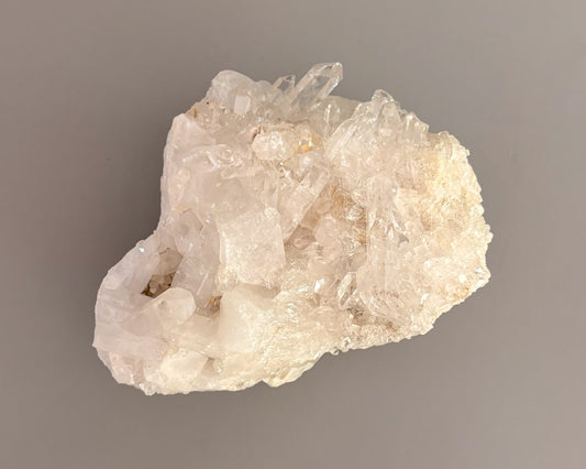 Natural clear quartz crystal cluster with translucent points and unique crystalline formations.