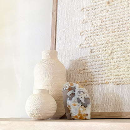 Organic modern shelf styling with natural stone sculpture and handcrafted ceramic vase