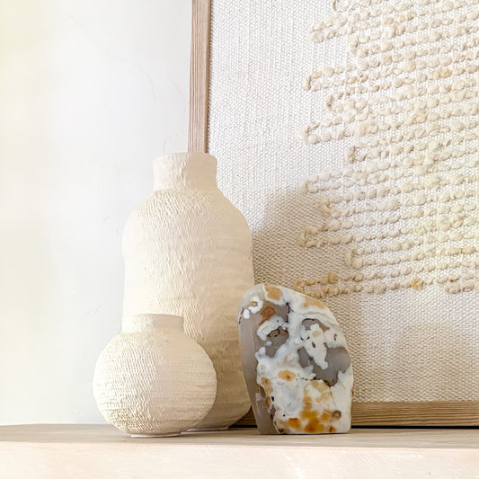 Luxury fern agate crystal sculpture with botanical-like inclusions on neutral styled shelf