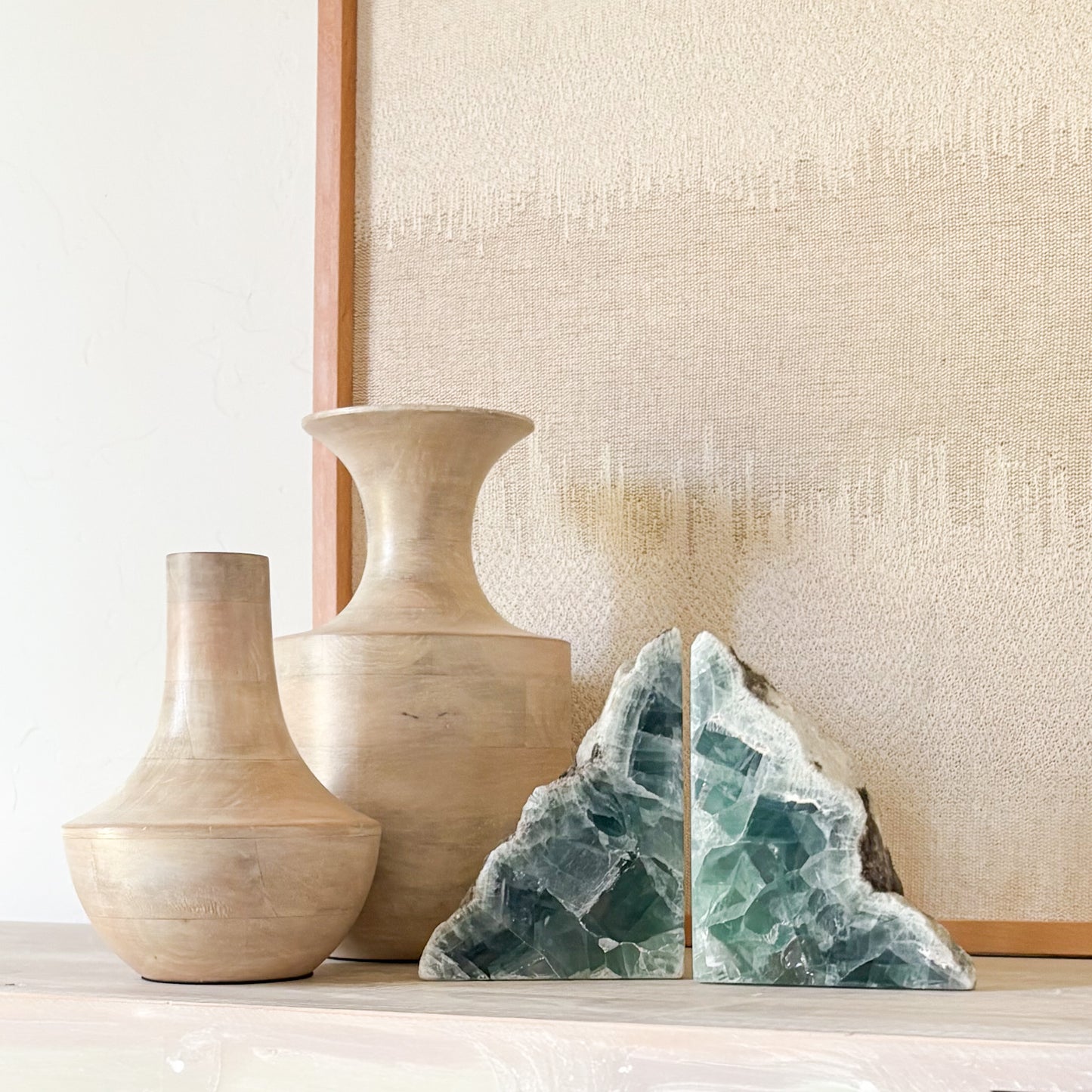 High-end fluorite bookends paired with handcrafted vases and linen backdrop