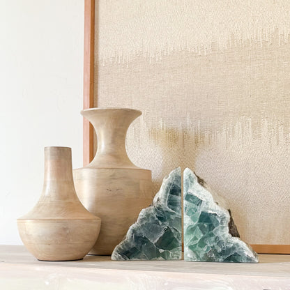 High-end fluorite bookends paired with handcrafted vases and linen backdrop