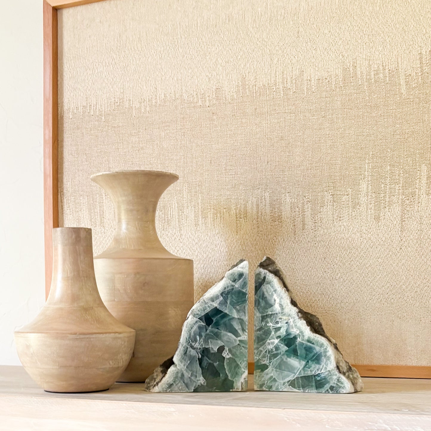 Natural fluorite crystal bookends with polished faces on a modern wooden shelf