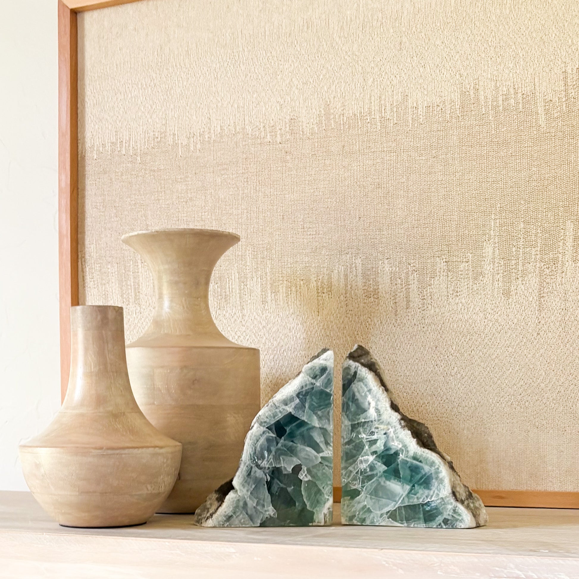 Natural fluorite crystal bookends with polished faces on a modern wooden shelf