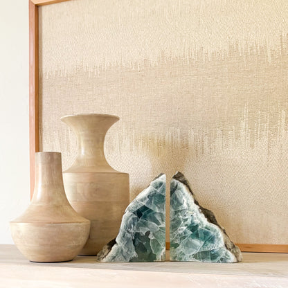 Natural fluorite crystal bookends with polished faces on a modern wooden shelf