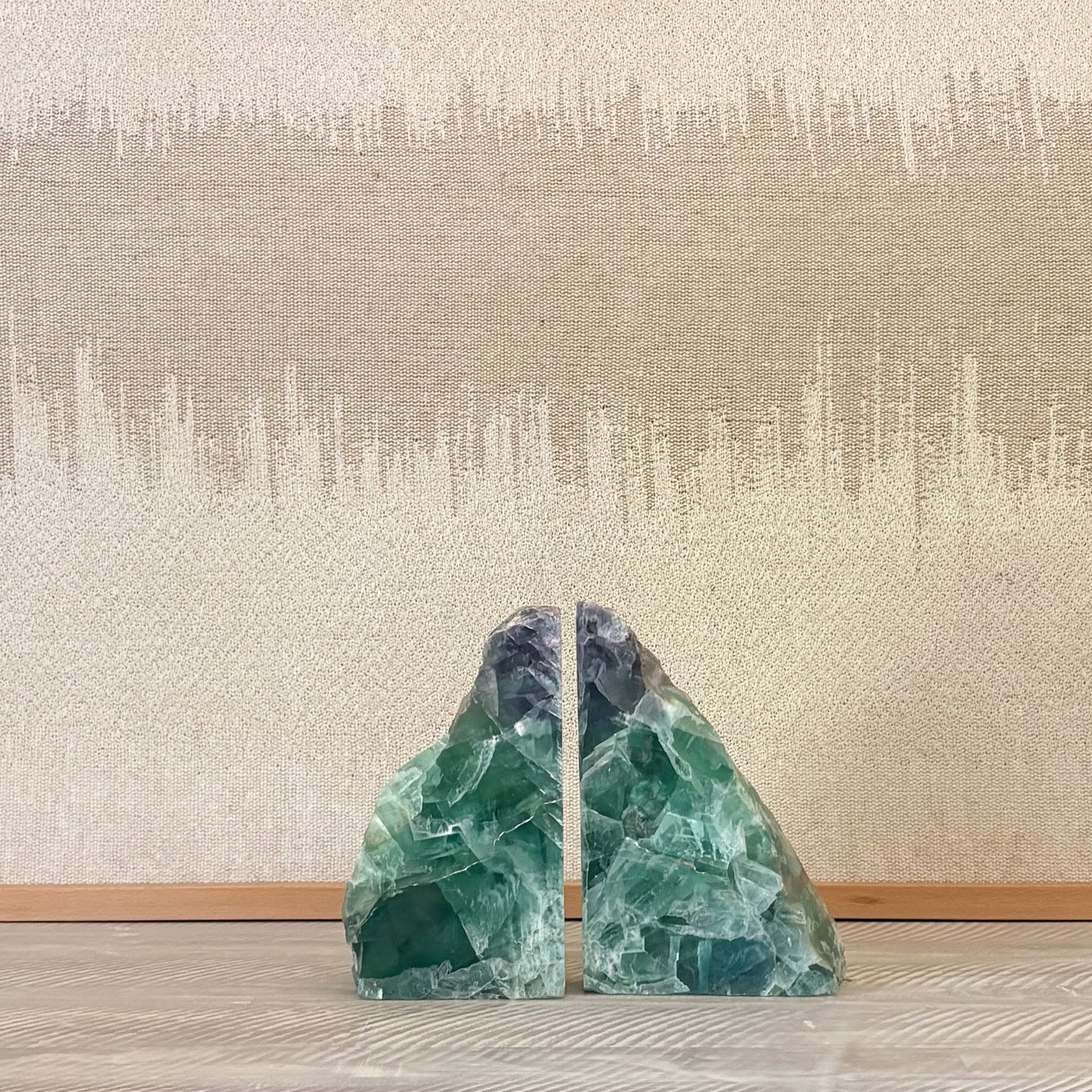 Polished fluorite gemstone bookends showcasing vibrant green, purple, and blue crystal layers