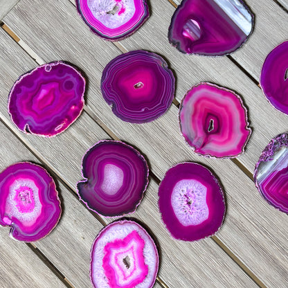Luxury fuchsia agate coaster set with organic crystal formations and polished finish for coffee tables and bars.