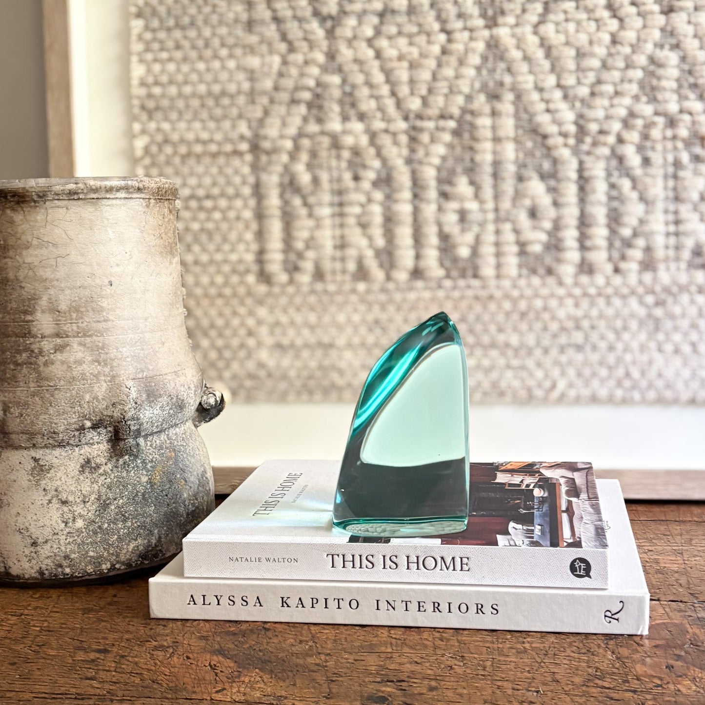Decorative glass piece on books with a textured wall in the background