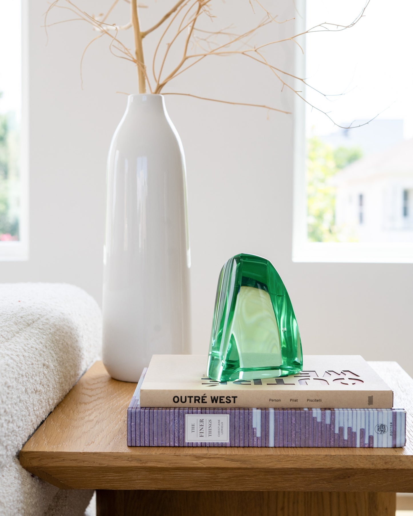Green art glass sculpture displayed on stacked design books