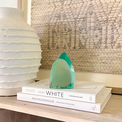 Abstract green glass sculpture on a shelf