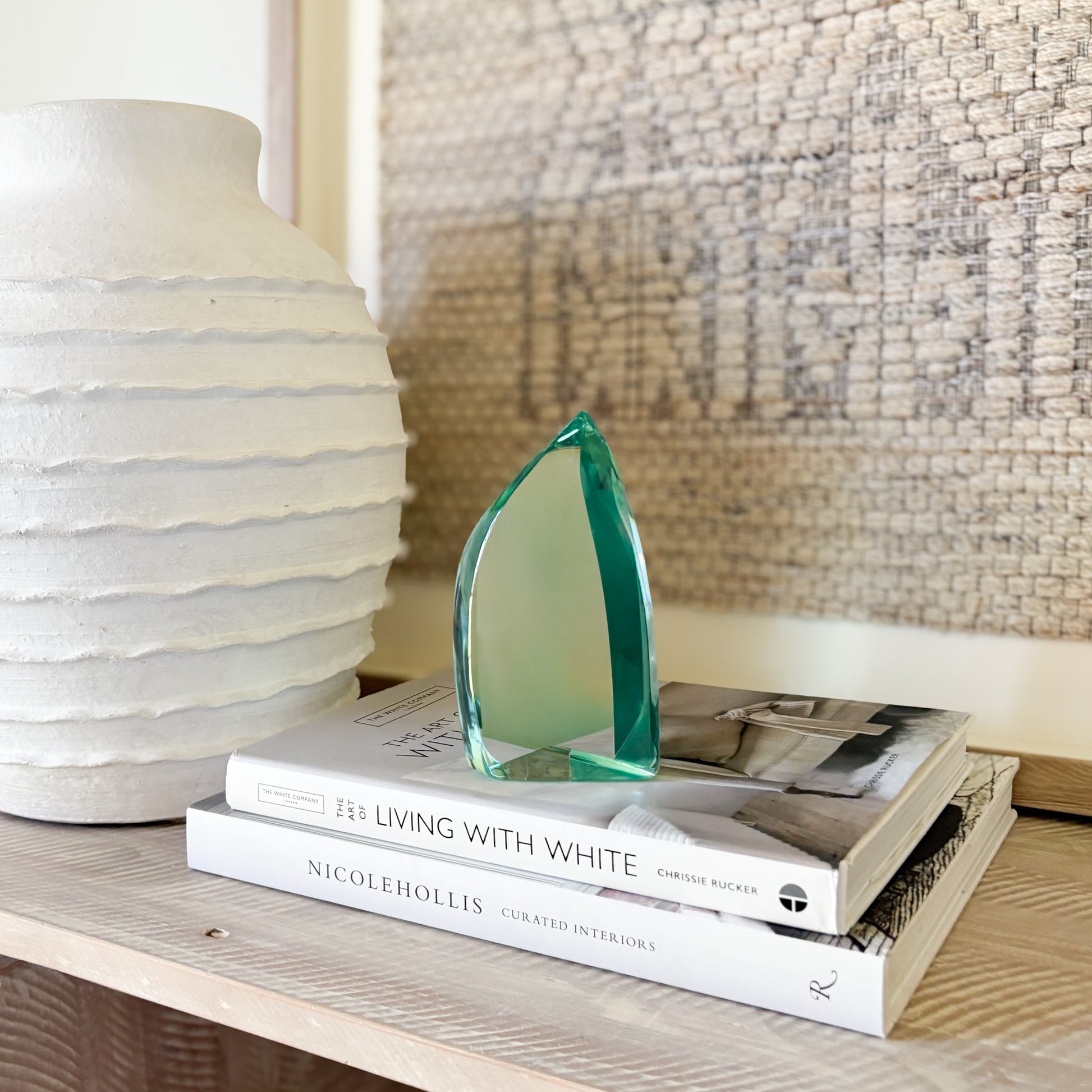 Green glass sculpture styled on shelf in modern minimalist interior