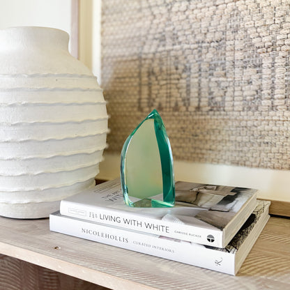 Green glass sculpture styled on shelf in modern minimalist interior