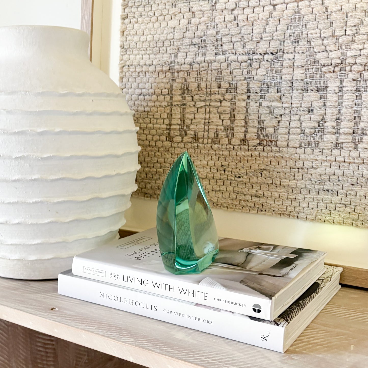 Modern green glass sculpture shown from side angle highlighting curves