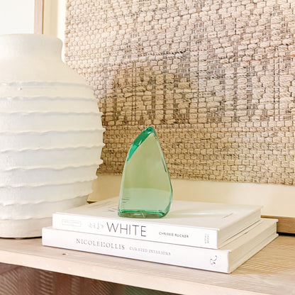 Abstract green glass sculpture on a shelf