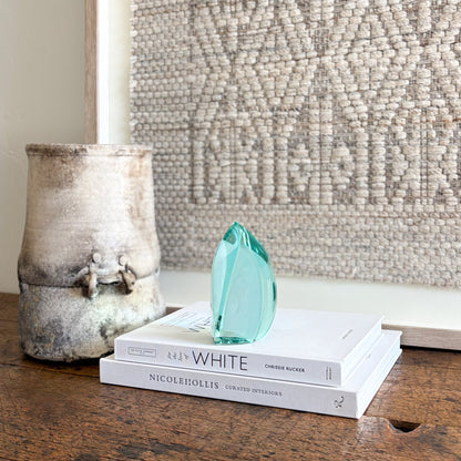 Green glass sculpture top view showing flowing abstract shape