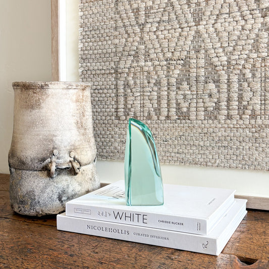 Handcrafted green glass art sculpture with smooth curved silhouette