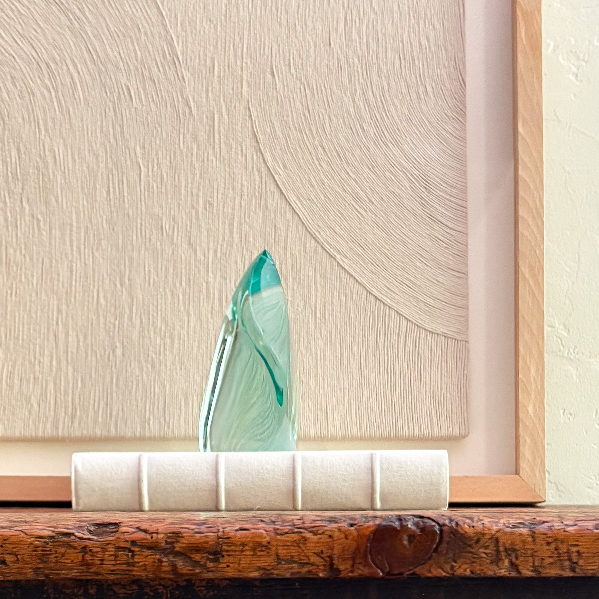 Contemporary emerald green glass sculpture reflecting light with fluid design