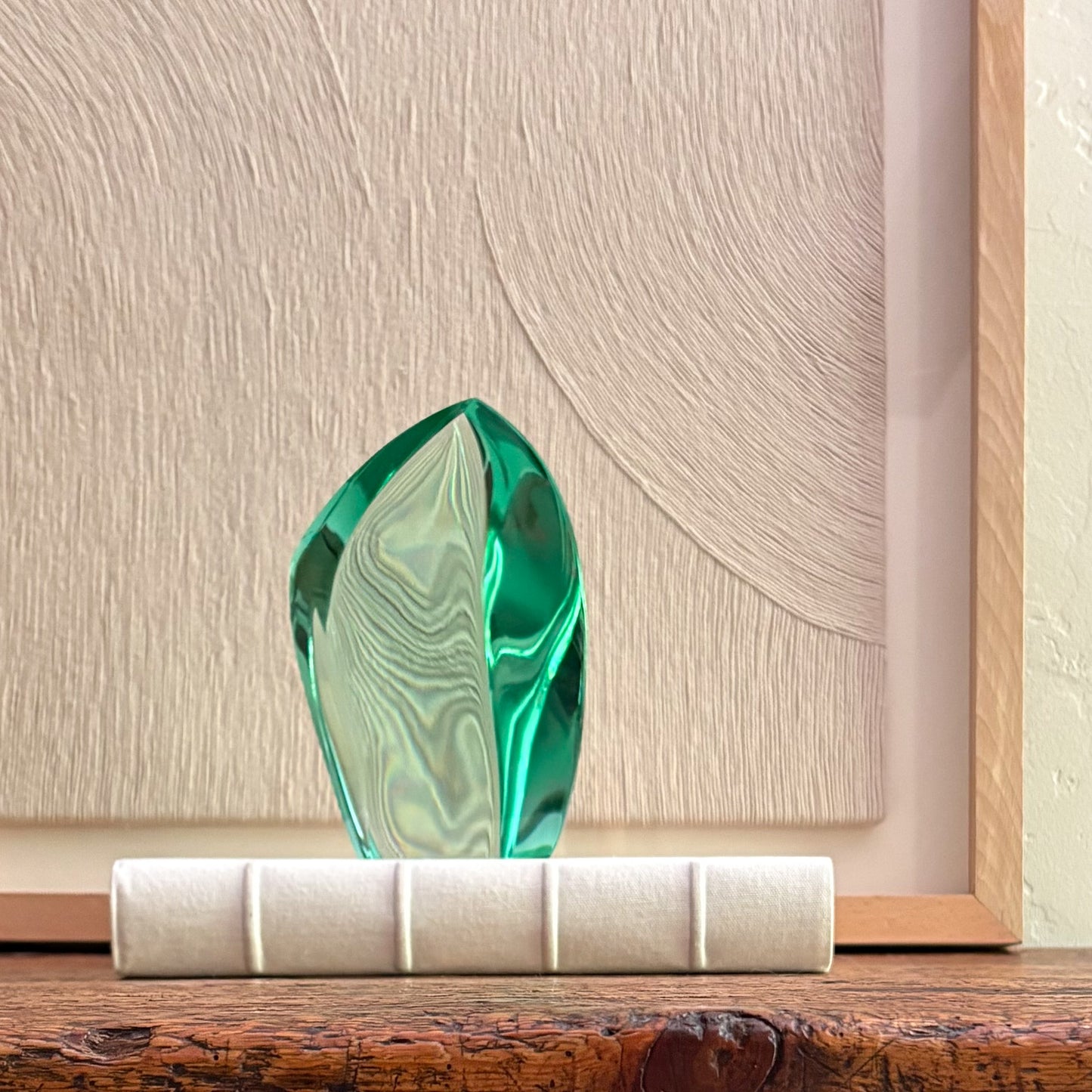 Artisan green glass sculpture with translucent finish and abstract form