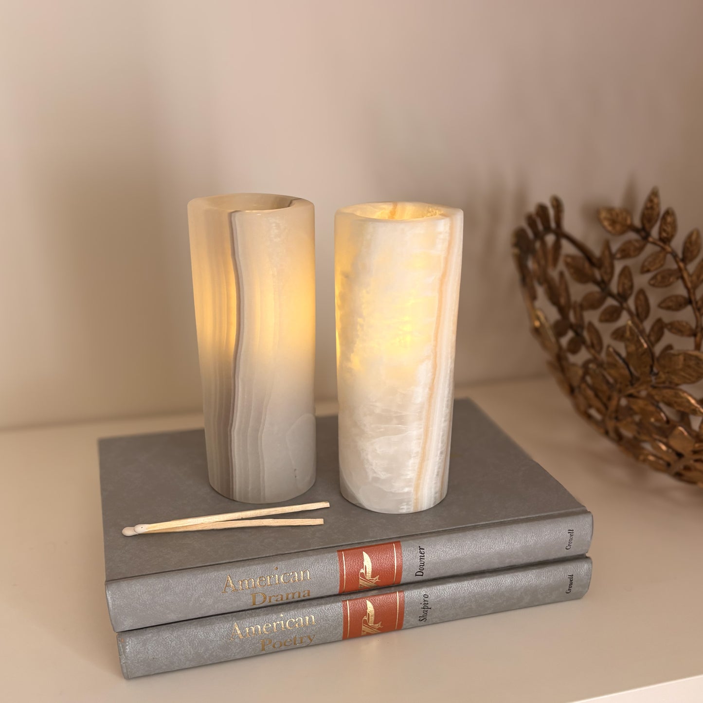 Sculptural grey aragonite candle holders displayed as refined shelf décor