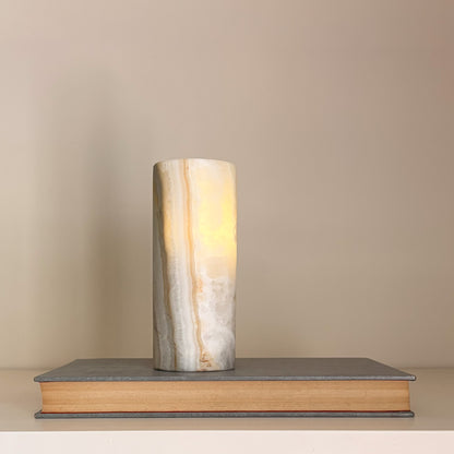 Natural stone tealight holders with translucent aragonite veining and soft candlelight