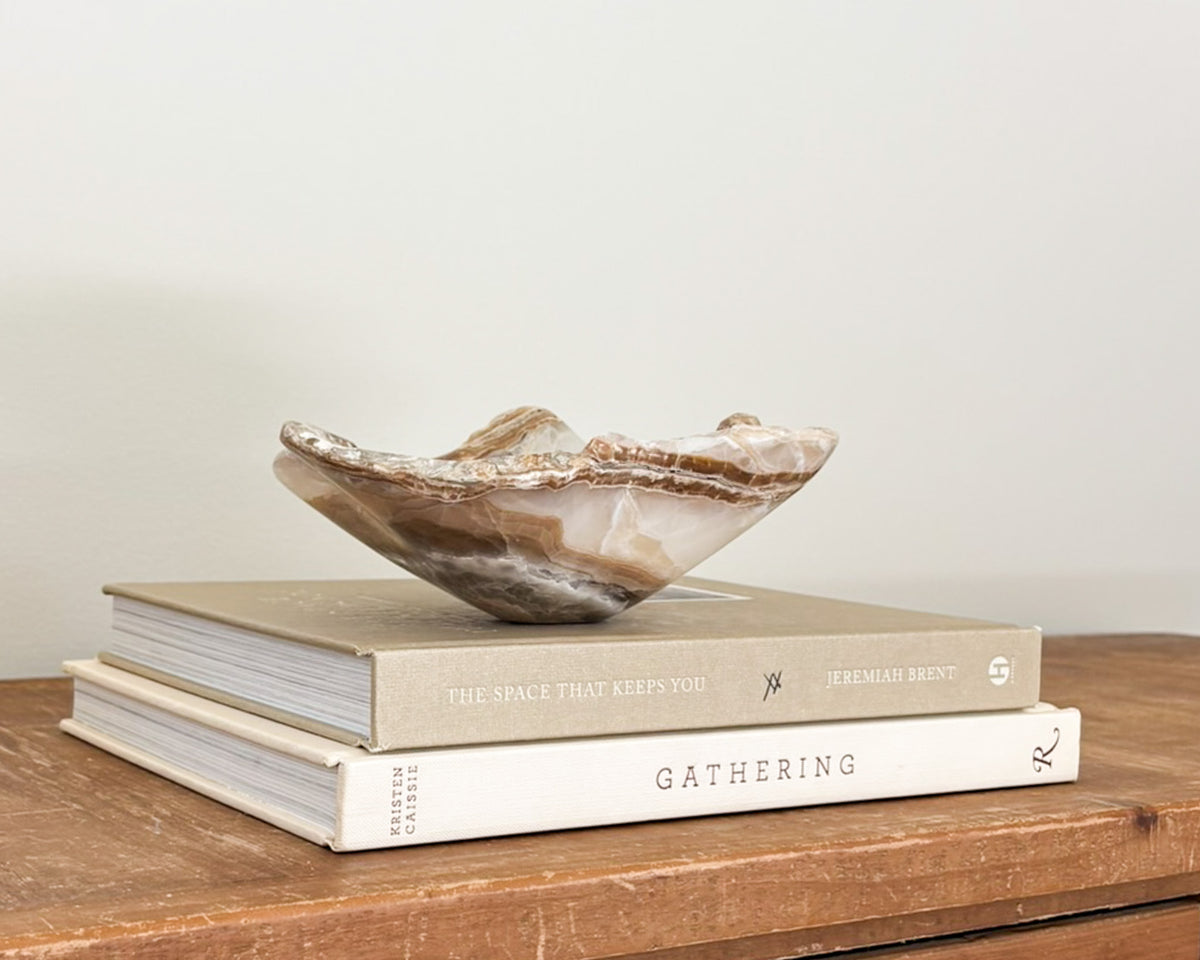 Polished amber onyx stone bowl with unique natural patterns and translucent details