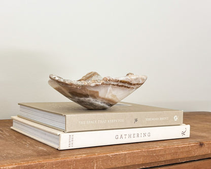Polished amber onyx stone bowl with unique natural patterns and translucent details