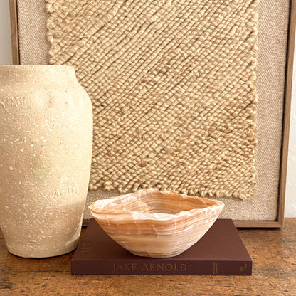 Handmade amber onyx bowl on tabletop, warm golden glow