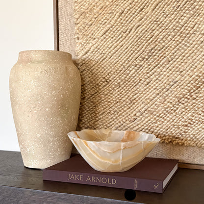 Hand carved amber onyx bowl used as a decorative centerpiece on table