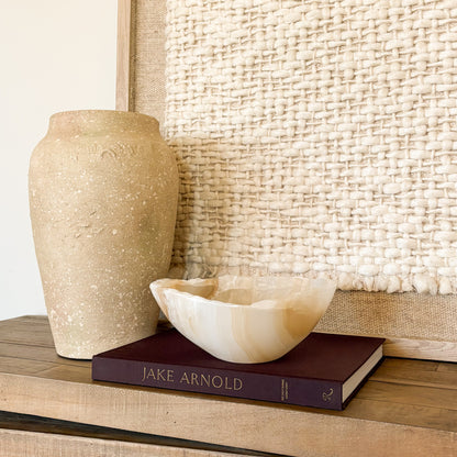 Hand carved amber onyx stone bowl with warm golden tones, artisan decor piece