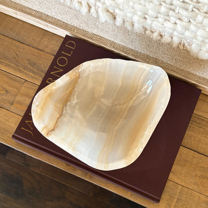 Artisan hand carved amber onyx bowl featuring unique natural stone patterns