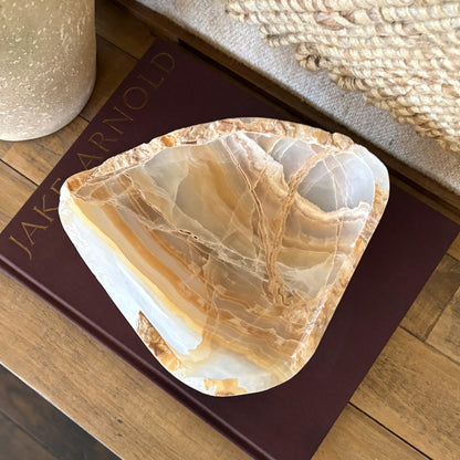 Close-up of luxury hand carved amber onyx bowl highlighting natural stone veining