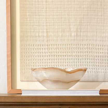 Artisan hand carved amber onyx bowl showcasing unique banded stone design