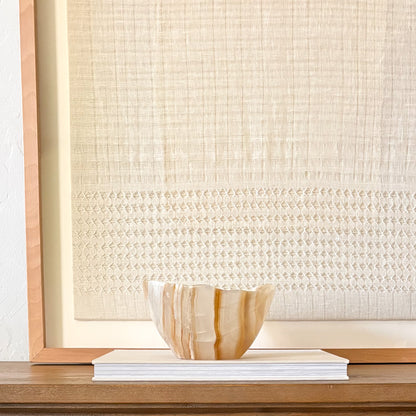Amber onyx bowl styled on shelf with minimalist interior design