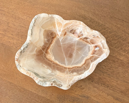 Polished amber onyx bowl with translucent golden brown coloring
