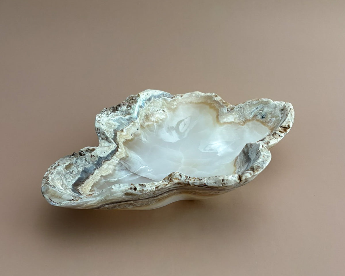 Hand-carved amber onyx bowl featuring warm golden tones, rich caramel veining, and natural stone variations