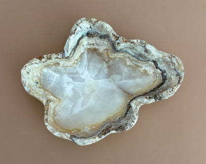 Decorative amber onyx bowl with distinctive natural banding and translucent honey-colored tones, hand-carved from solid stone