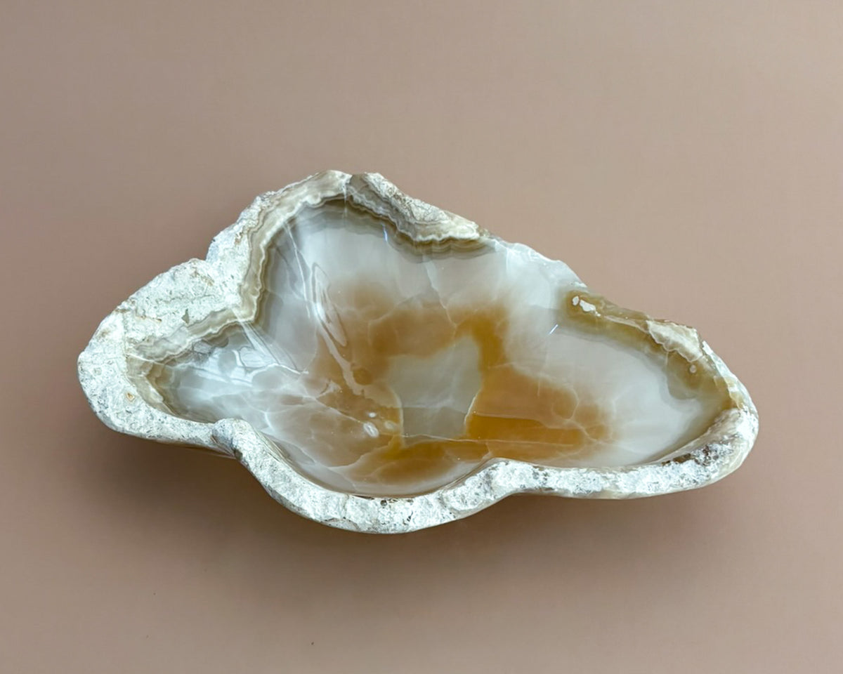 Hand-carved amber onyx bowl featuring warm golden tones, rich caramel veining, and natural stone variations