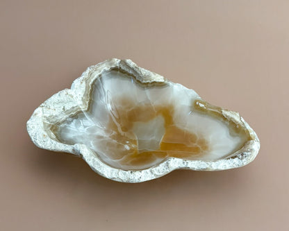 Hand-carved amber onyx bowl featuring warm golden tones, rich caramel veining, and natural stone variations