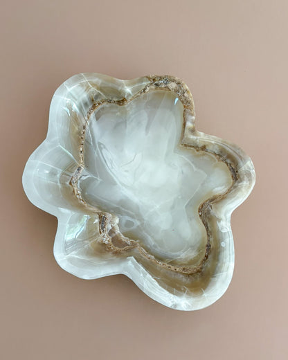 Decorative amber onyx bowl with distinctive natural banding and translucent honey-colored tones, hand-carved from solid stone