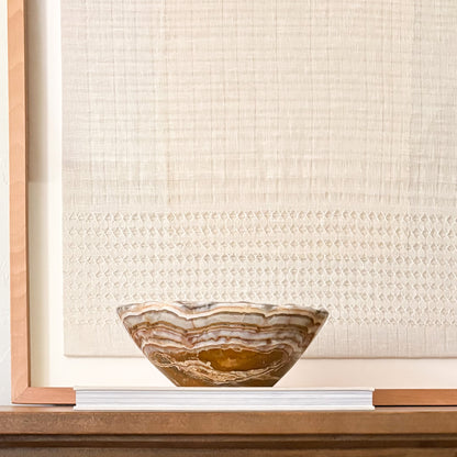 Natural stone bowl displayed on minimalist shelf