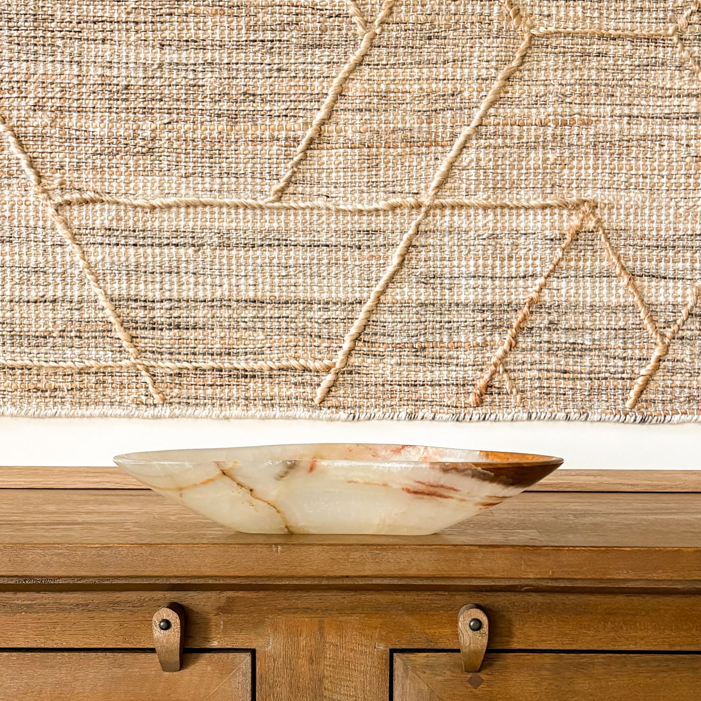 Polished brown onyx bowl with natural veining displayed on rustic wooden table