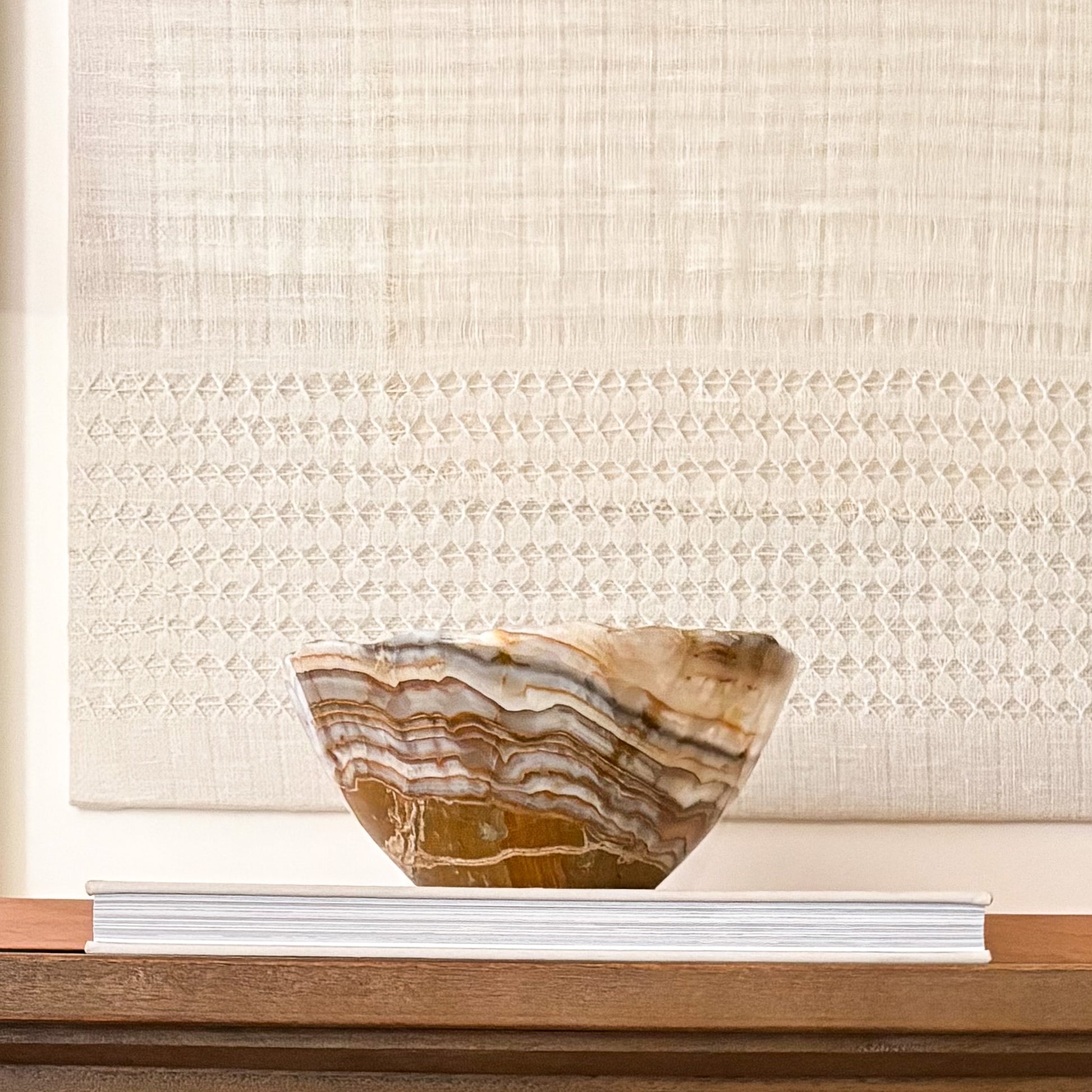 Brown onyx bowl styled on coffee table with modern decor