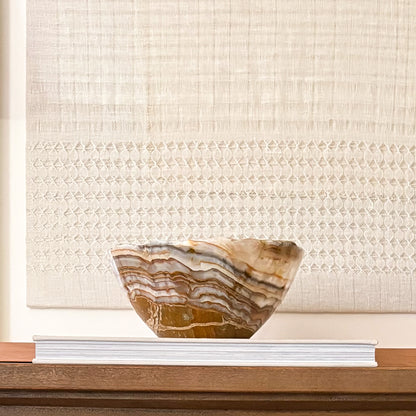 Brown onyx bowl styled on coffee table with modern decor